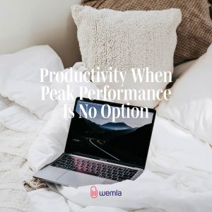 Laptop on bed with neutral bedding and text Productivity when peak performance is no option