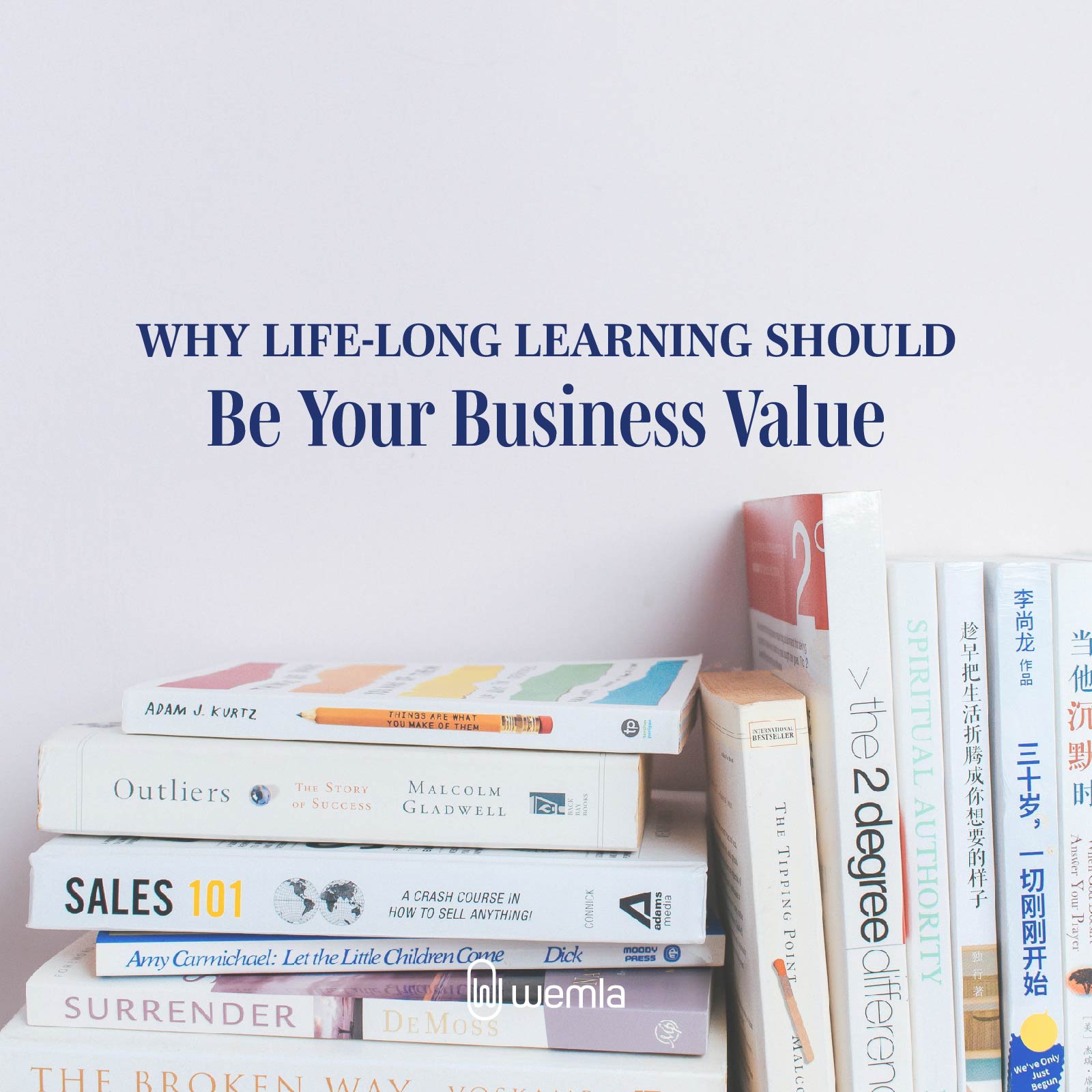 A stack of business books against a white wall and text Why life-long learning should be your business value