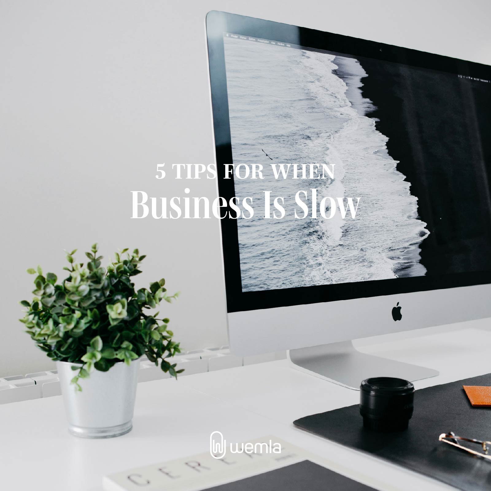 Desk with iMac plant stationery and text Five tips for when business is slow